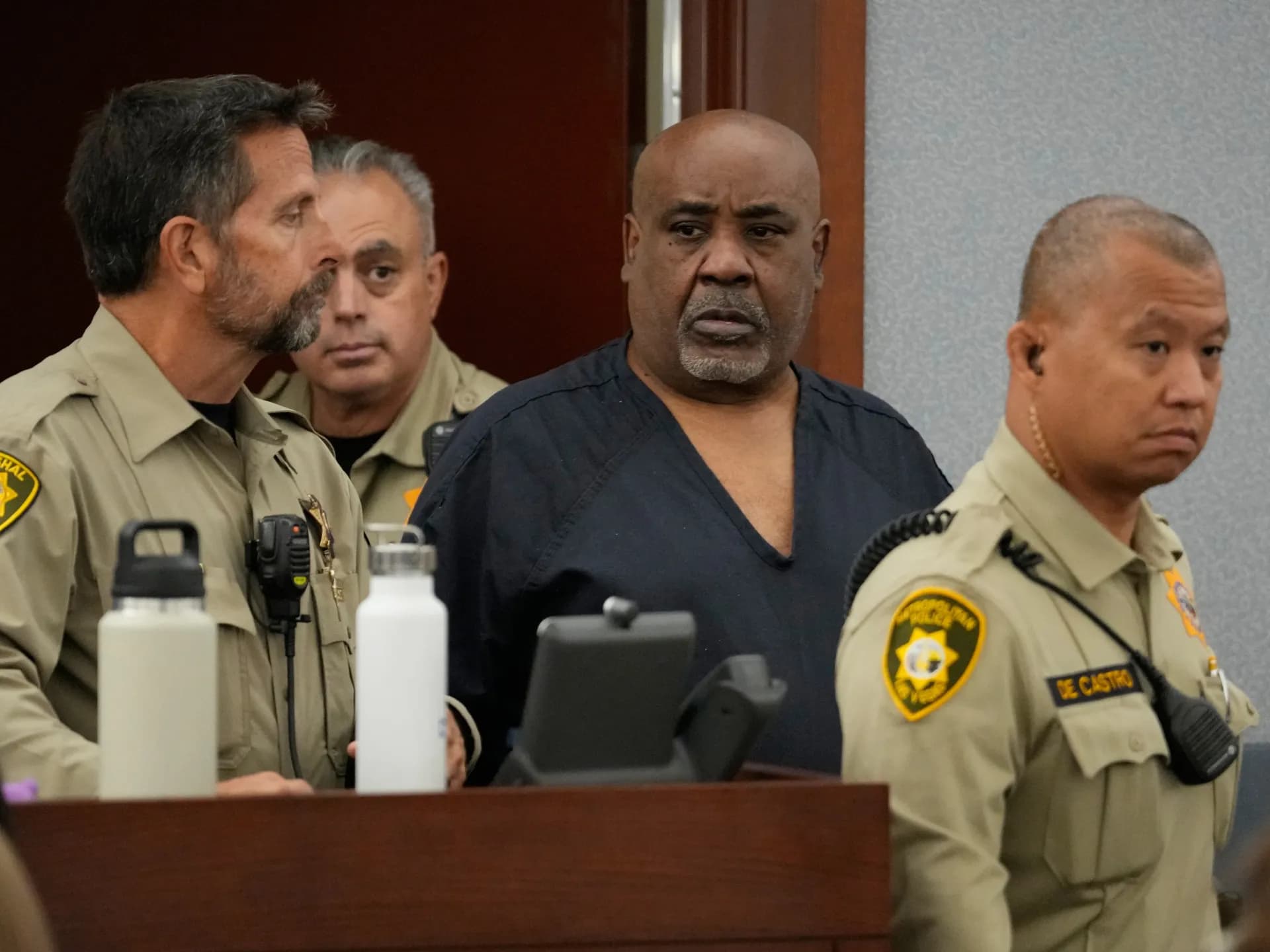Duane «Keffe D» Davis, con uniforme de preso, entre agentes en una sala de tribunal de Las Vegas