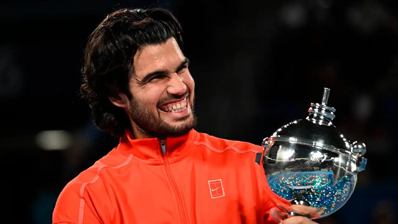 Carlos Alcaraz sonríe con el trofeo de campeón del Abierto de Japón en Tokio