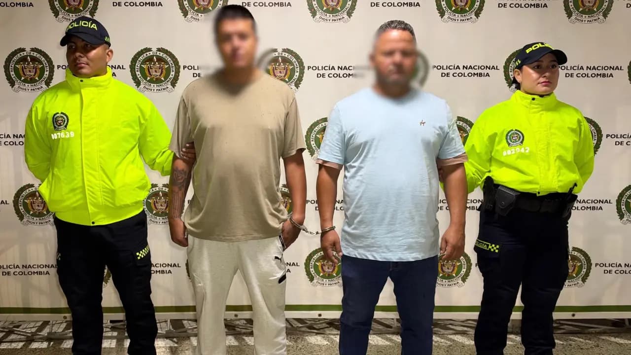 Dos hombres con el rostro difuminado, custodiados por policías, tras su captura por el homicidio de un pensionado en Medellín