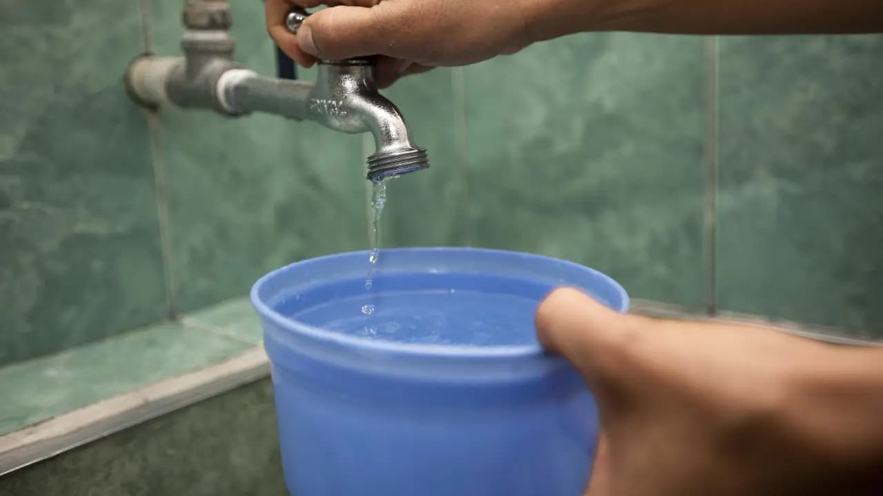 Habitantes de Medellín recogen agua durante una interrupción del servicio