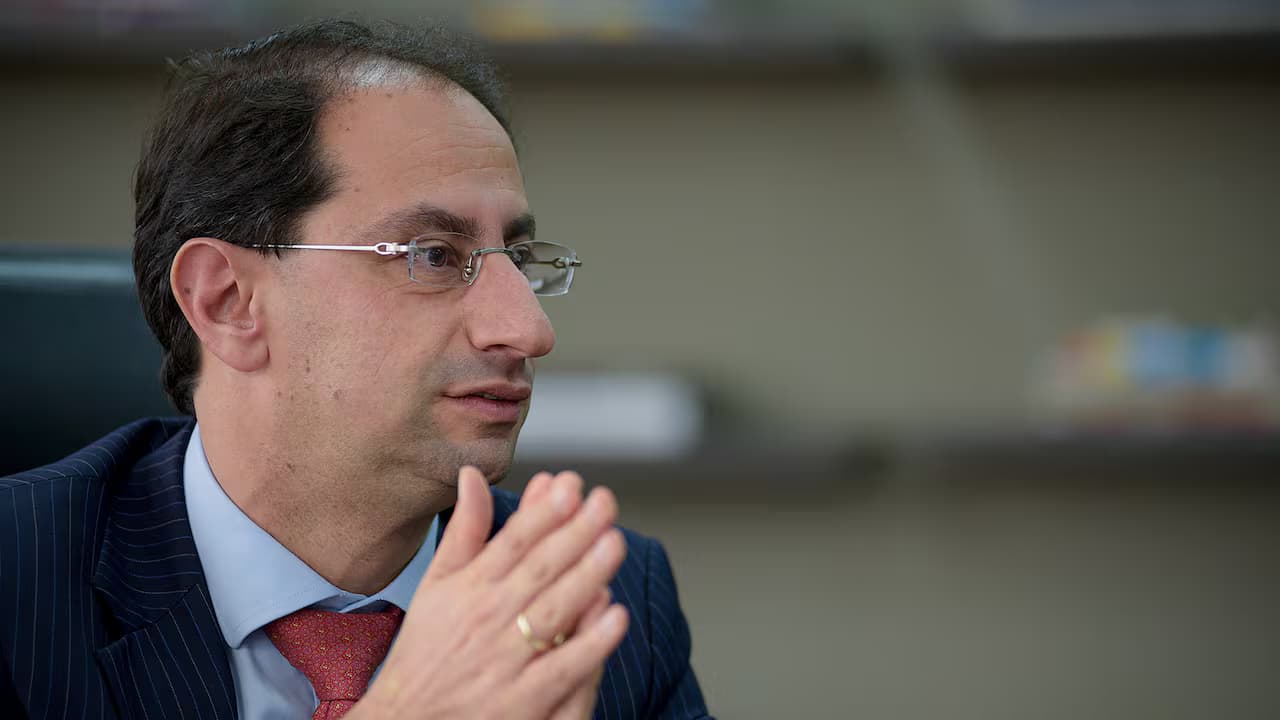 José Manuel Restrepo, con gafas y traje oscuro, habla con las manos juntas sentado en un despacho
