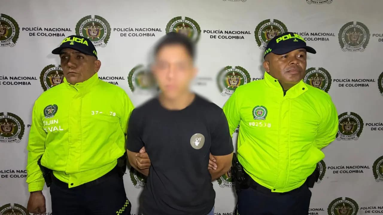 Dos policías de la Sijín custodian al capturado, con el rostro difuminado