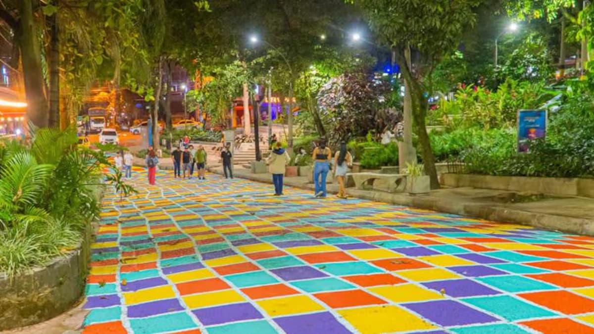 Visitantes caminan de noche por el Parque Lleras, en El Poblado, Medellín