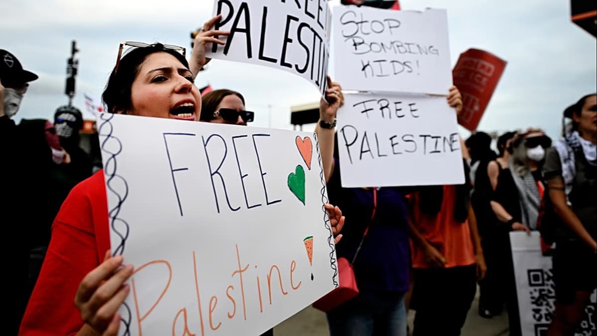 Manifestantes con carteles a favor de Palestina frente a un estadio
