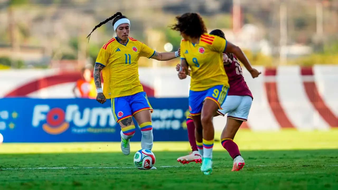 Jugadoras de la selección Colombia femenina conducen el balón ante Venezuela en Isla Margarita