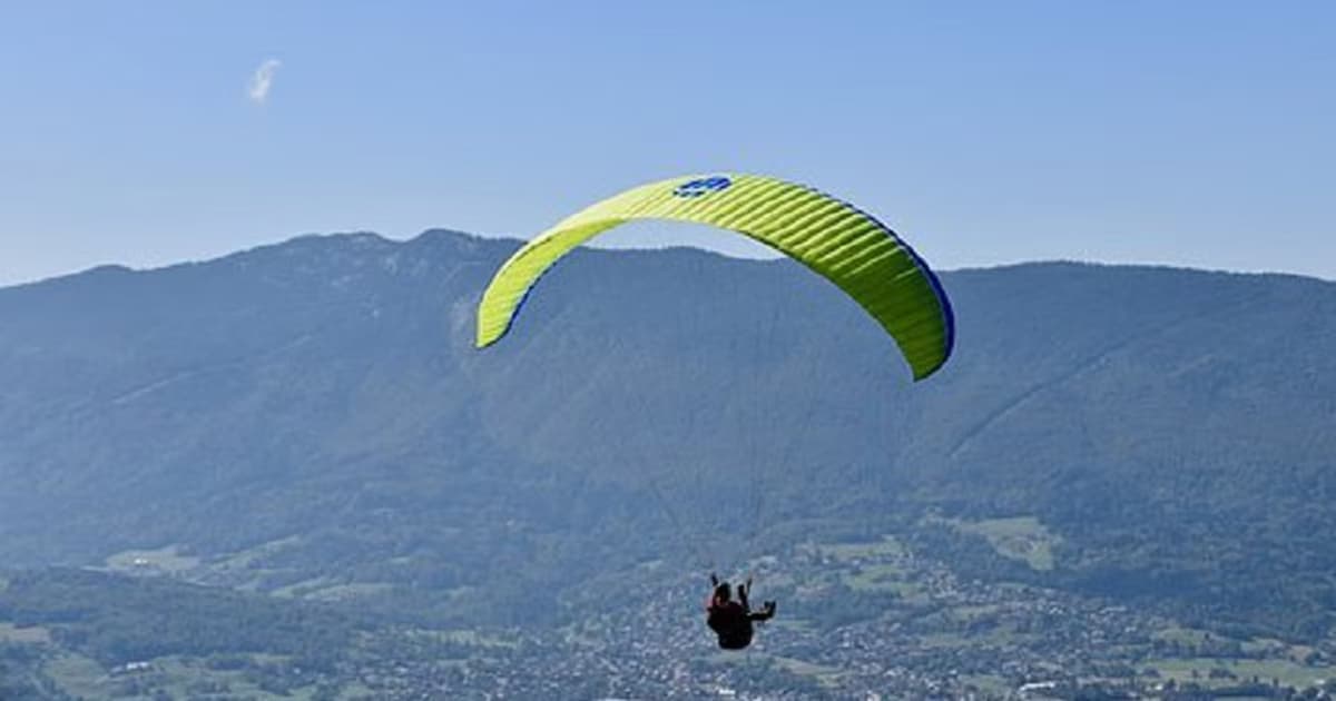 Un parapente doble sobrevuela un valle de montaña