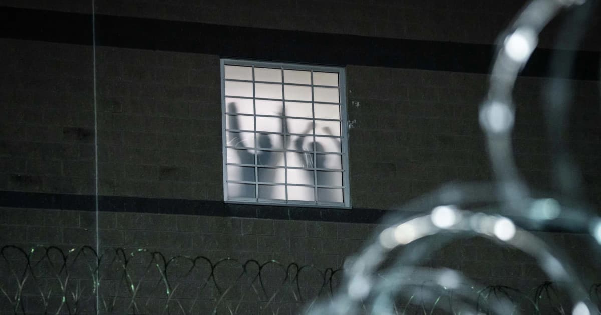 Siluetas de detenidos tras la ventana enrejada de Delaney Hall, un centro de detención de ICE en Newark, Nueva Jersey
