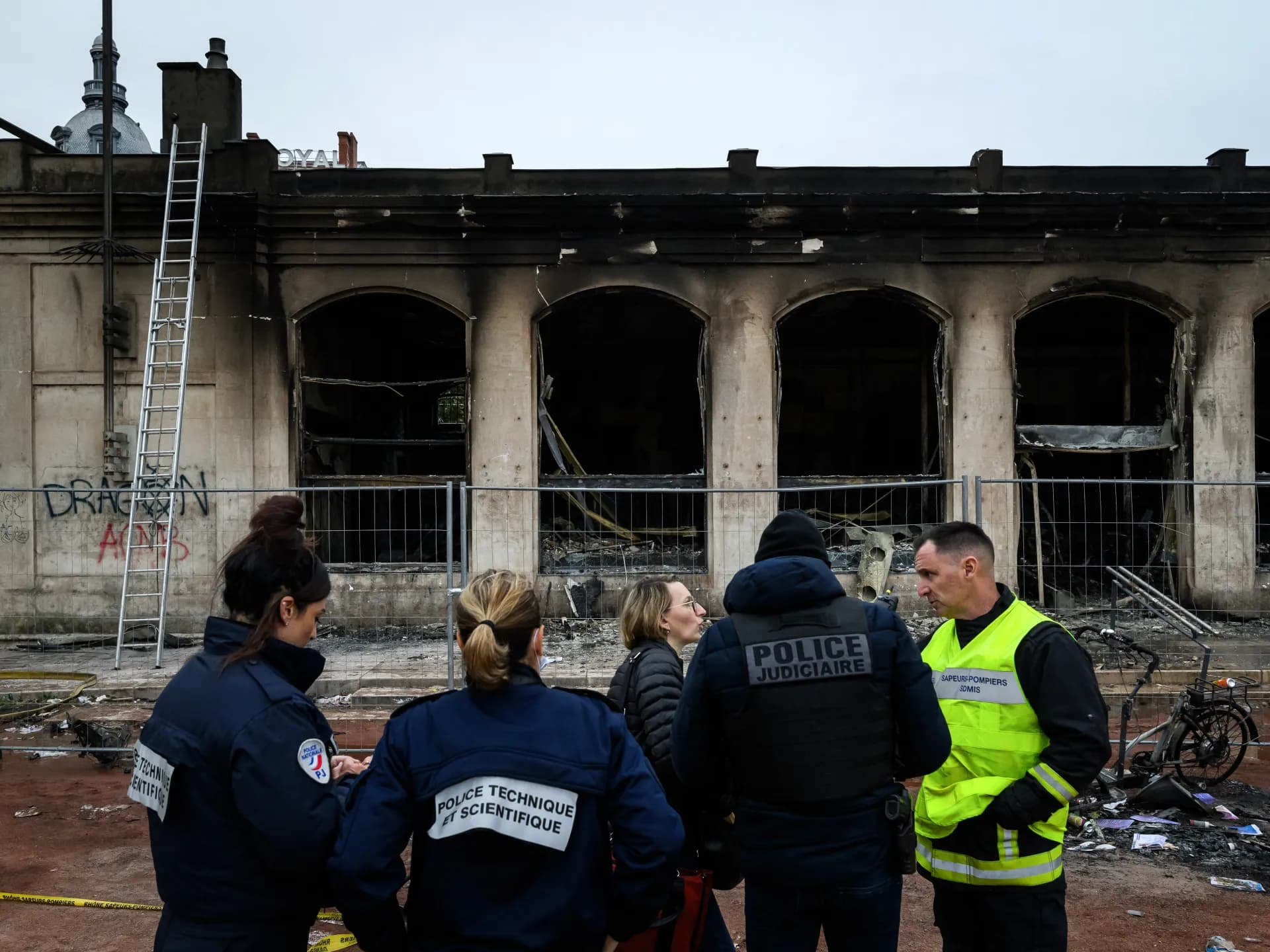 Agentes de la policía científica francesa frente a un edificio incendiado durante los disturbios