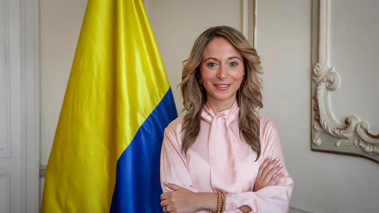 Julia Cristina Daza Noguera, nueva directora de la Biblioteca Nacional, junto a la bandera de Colombia