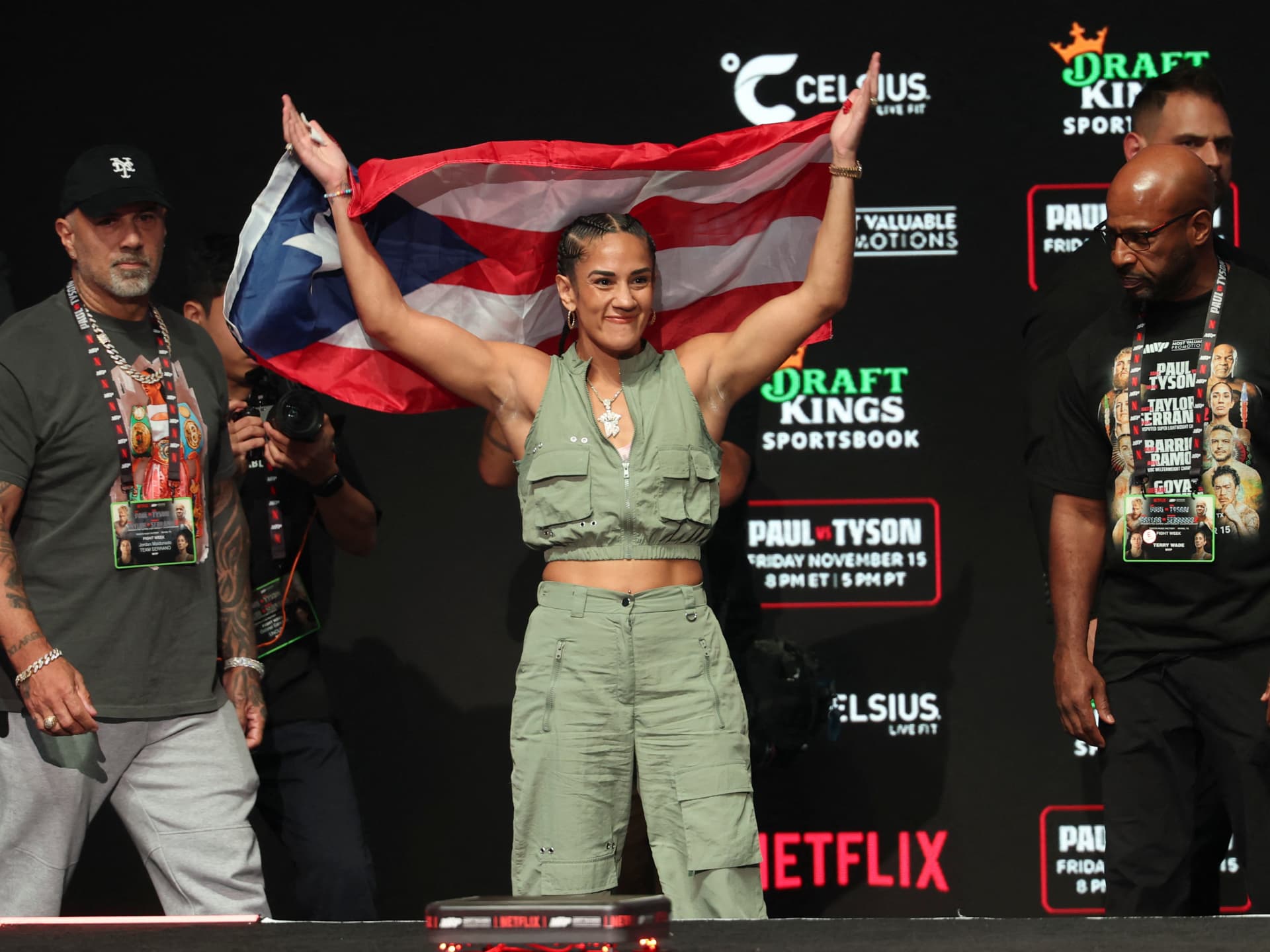Amanda Serrano levanta la bandera de Puerto Rico durante un pesaje en 2024