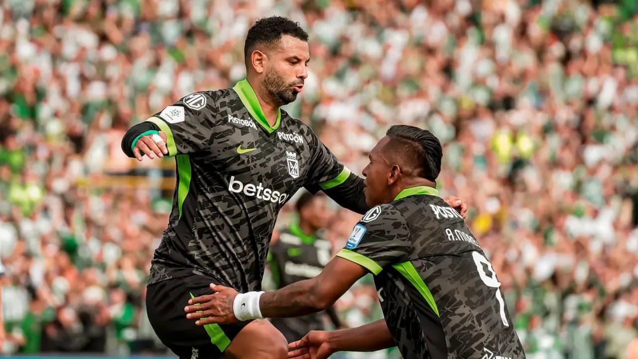 Dos jugadores de Atlético Nacional celebran un gol abrazados durante el partido en El Campín