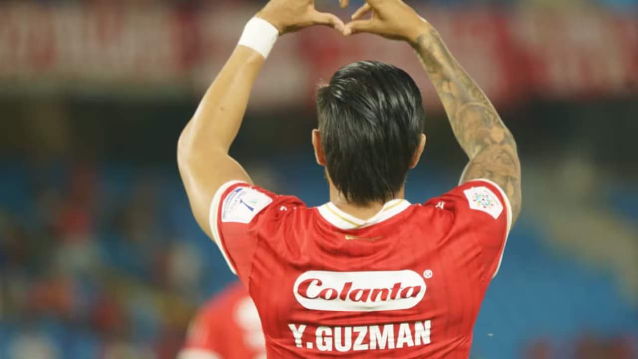 Yeison Guzmán, de espaldas, celebra con las manos en forma de corazón su gol de penal ante Águilas Doradas
