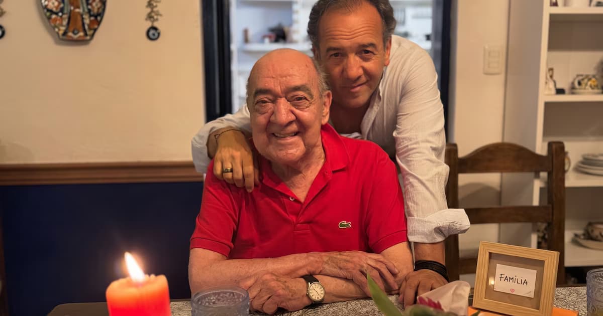 El periodista Yamid Amat sonríe sentado a la mesa junto a su hijo Yamid Amat Serna