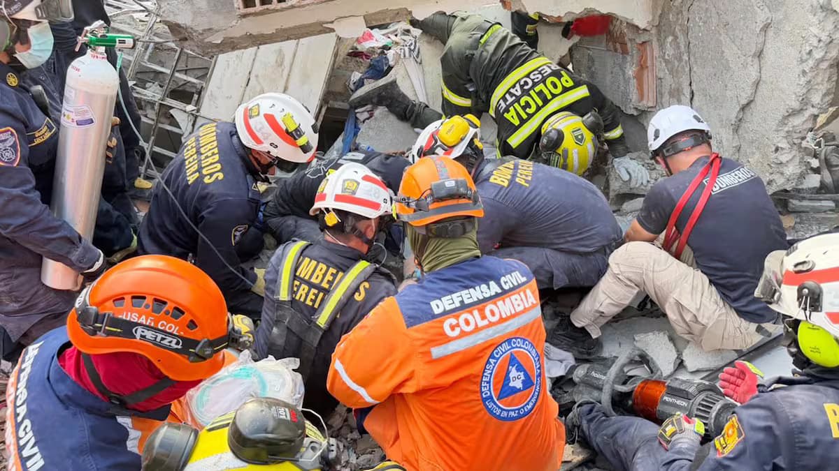 Bomberos, policías y socorristas de la Defensa Civil trabajan entre los escombros del edificio colapsado en Pereira