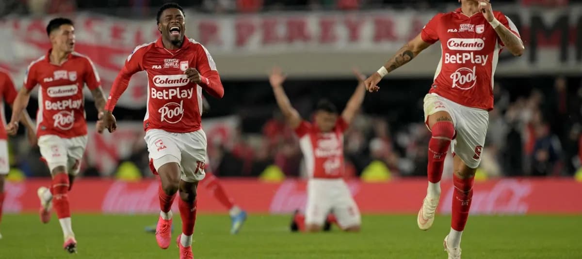 Jugadores de Santa Fe corren gritando por el césped del estadio Monumental mientras otros caen de rodillas celebrando la clasificación