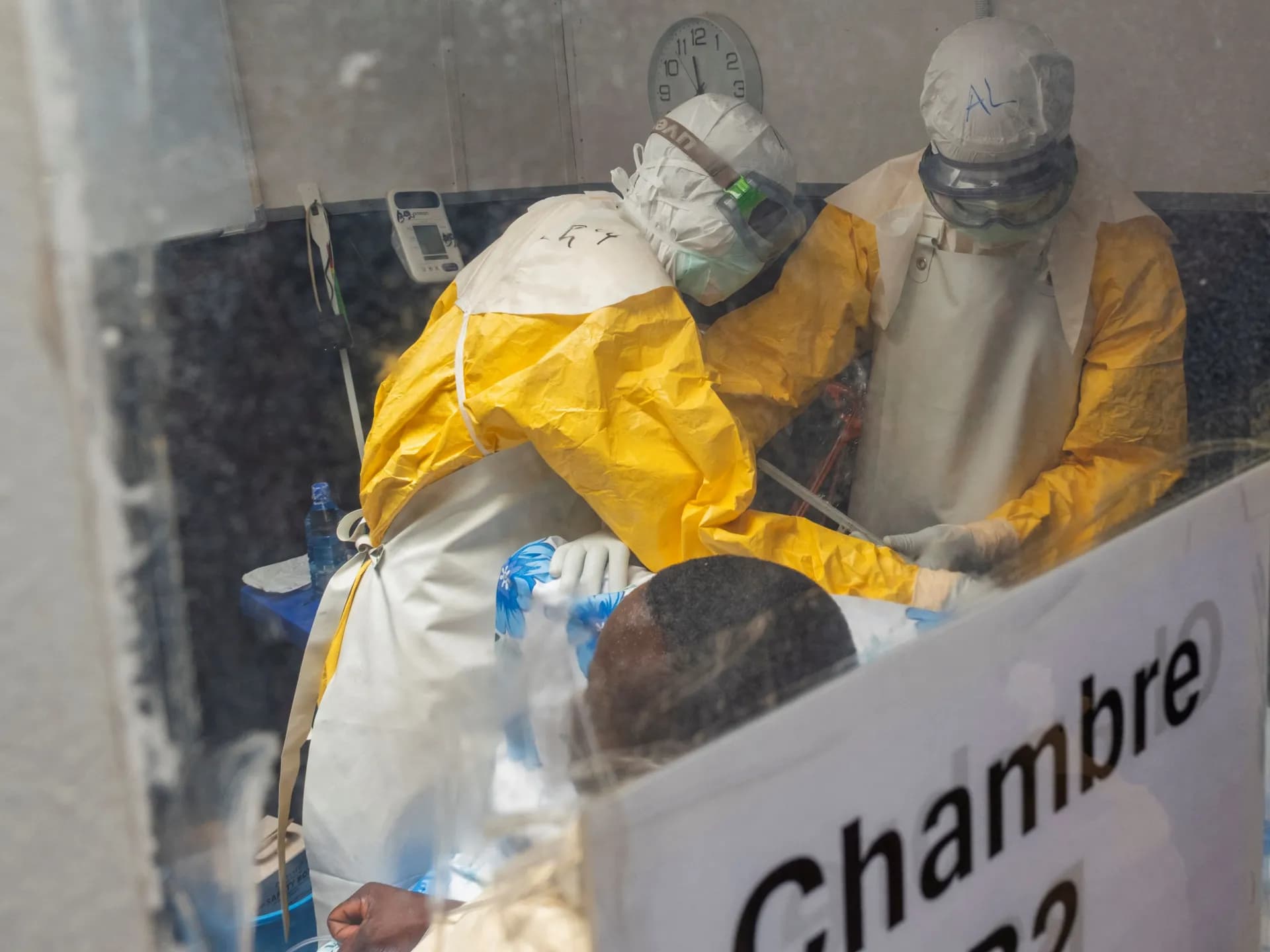 Trabajadores de salud con trajes de protección atienden a un paciente en un centro de tratamiento del ébola en Kitatumba, RD Congo