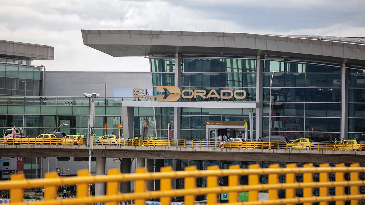 Fachada del Aeropuerto Internacional El Dorado, en Bogotá, con taxis en la vía de acceso