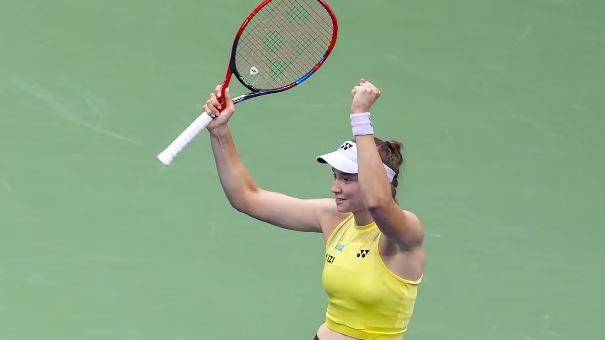 Elena Rybakina levanta los brazos con la raqueta en la mano para celebrar su victoria