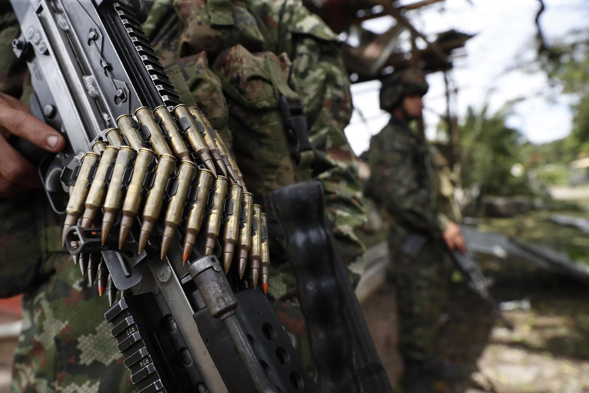 Un soldado sostiene un fusil con cinta de munición durante un operativo militar en zona selvática