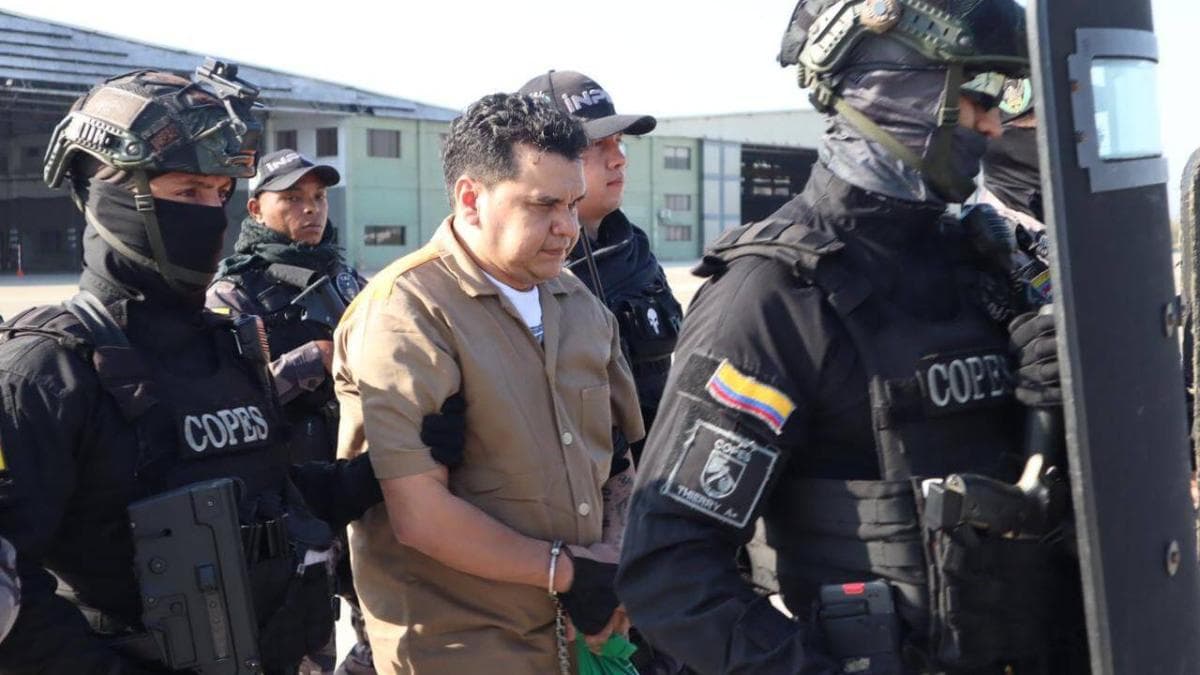 Un recluso con uniforme beige es custodiado por agentes del grupo Copes del Inpec durante un traslado