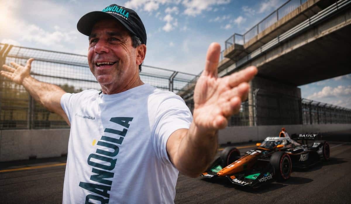 El alcalde Alejandro Char, con gorra y camiseta de Barranquilla, abre los brazos en una pista con un monoplaza de IndyCar al fondo