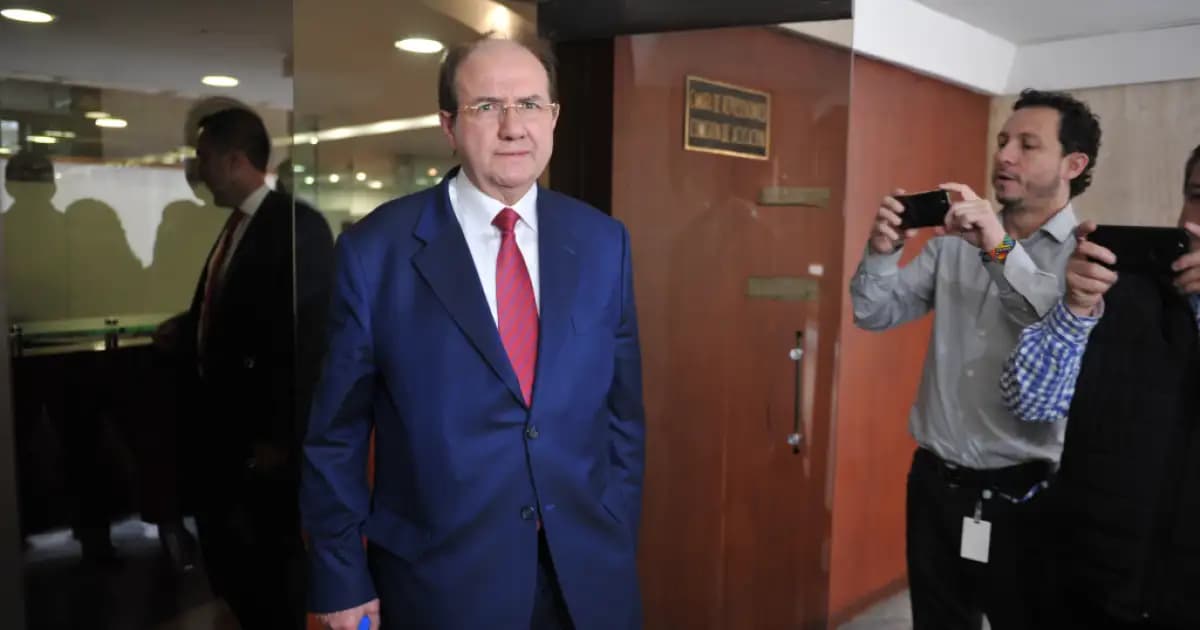 El exmagistrado Leonidas Bustos en un pasillo, observado por periodistas que lo graban con sus celulares