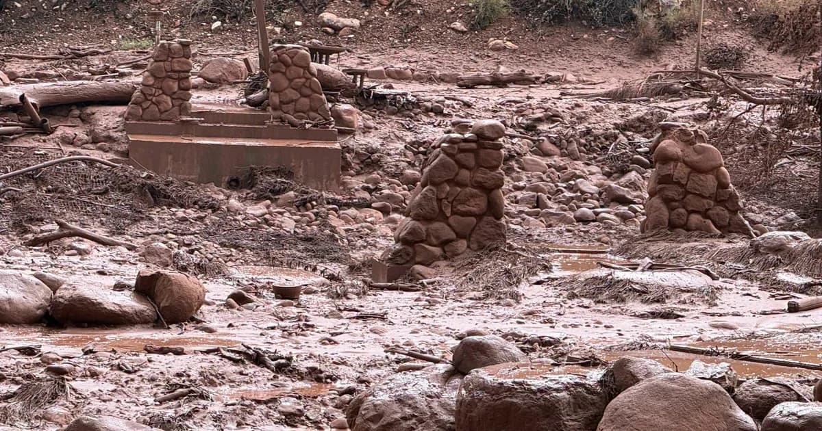 Restos de estructuras de piedra y troncos entre el lodo rojizo que dejó la creciente en el fondo del cañón