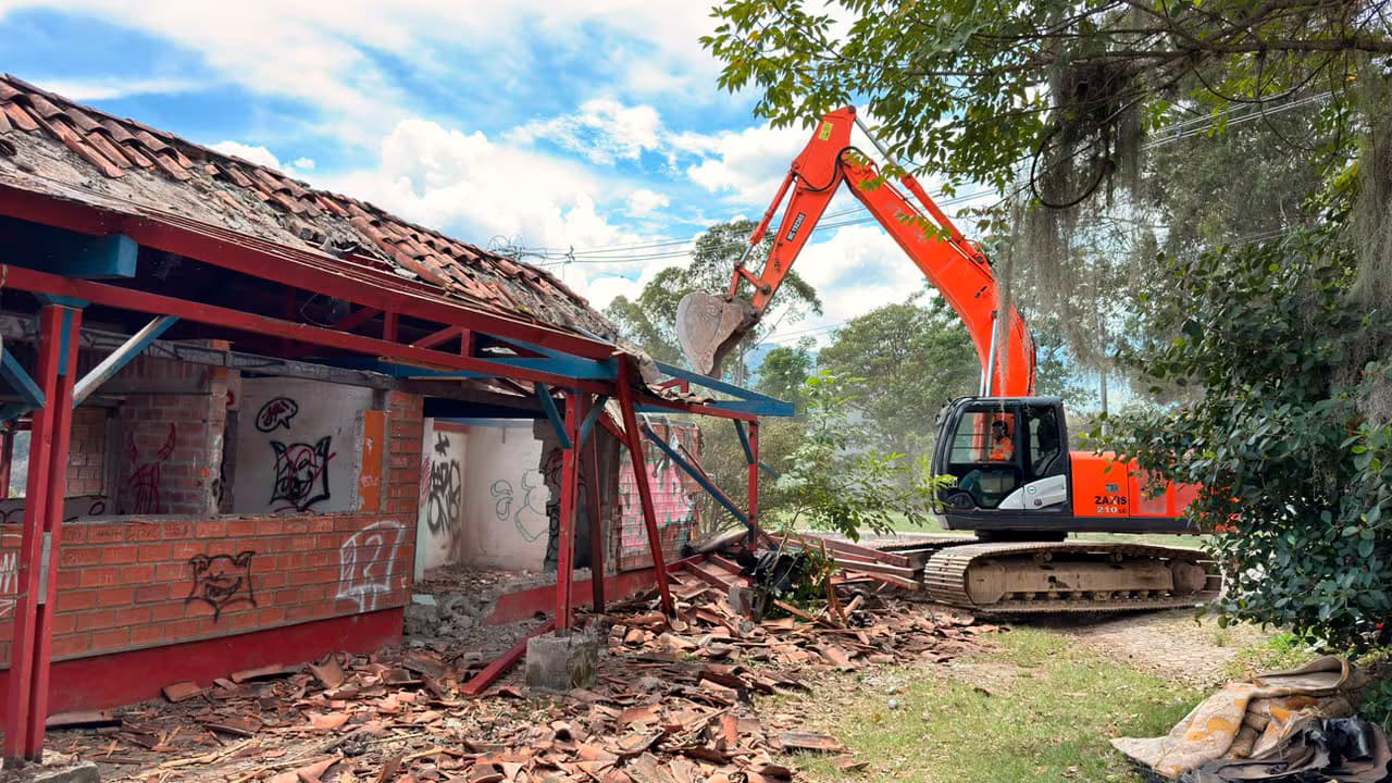 Una retroexcavadora derriba las antiguas pesebreras en San Cristóbal, Medellín