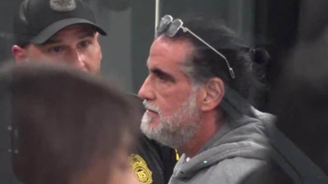 Alex Saab, con barba blanca y el cabello recogido, custodiado por un agente federal de Estados Unidos