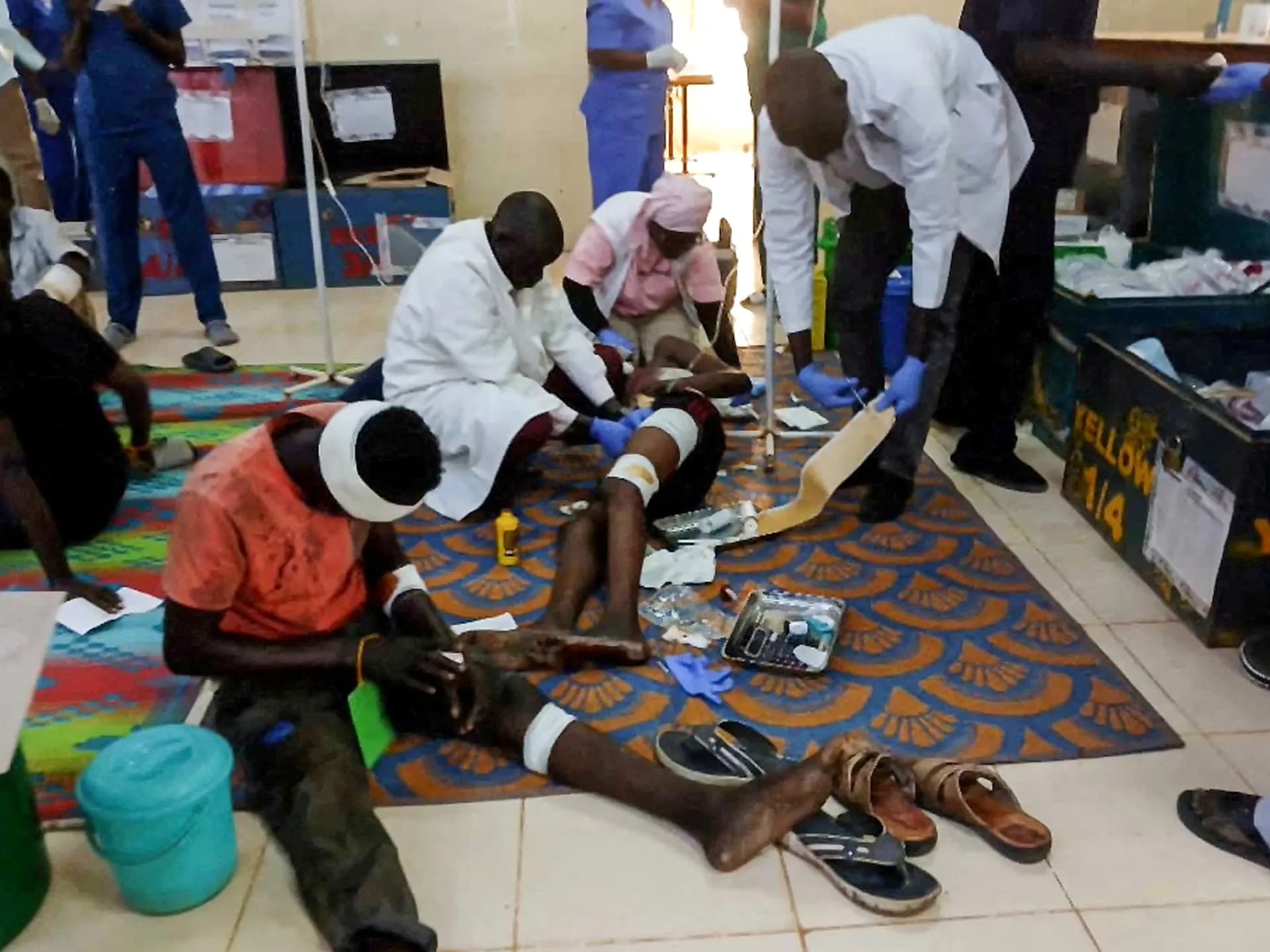Personal médico atiende a heridos sentados en el piso de un hospital tras el ataque con drones en Abyei