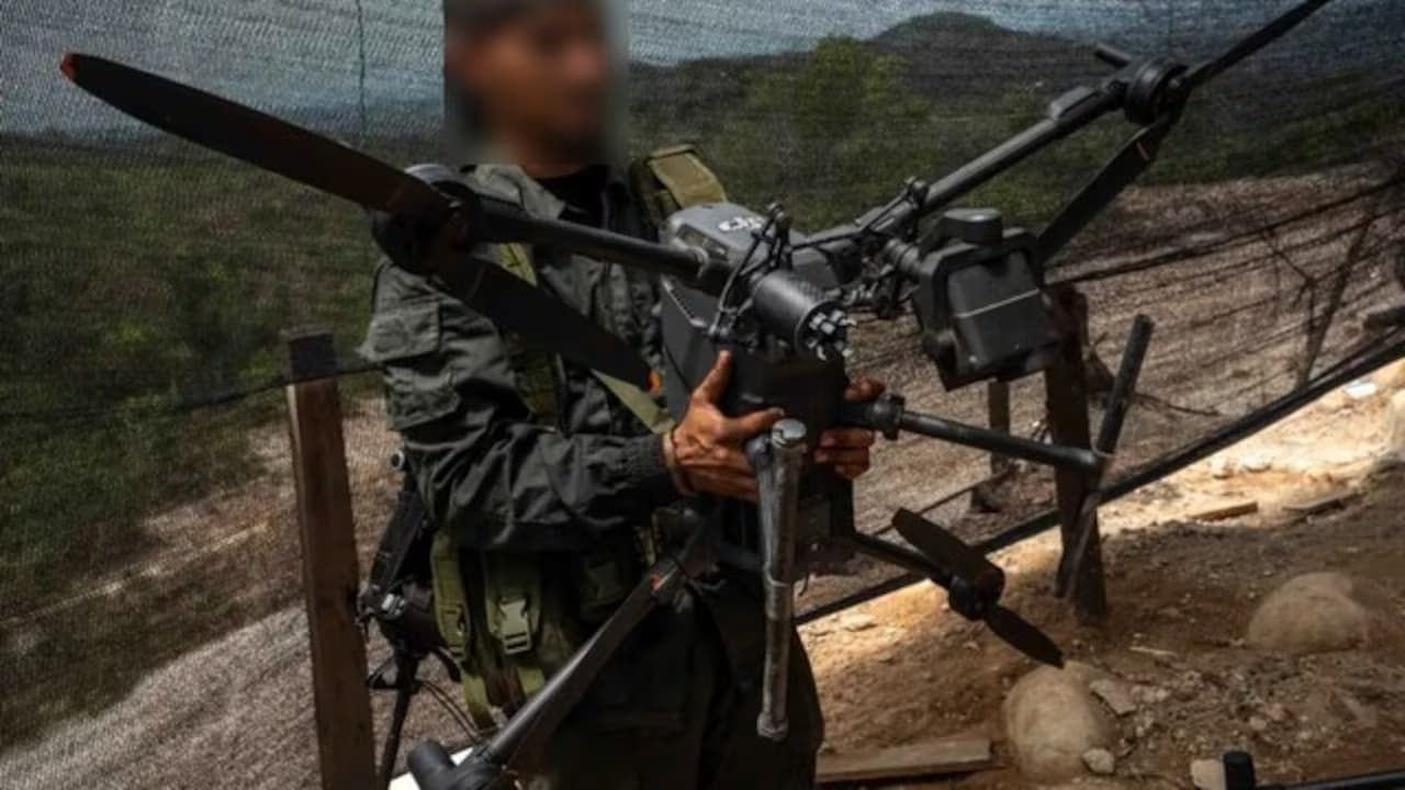 Un hombre armado sostiene un dron de uso militar (imagen de archivo)