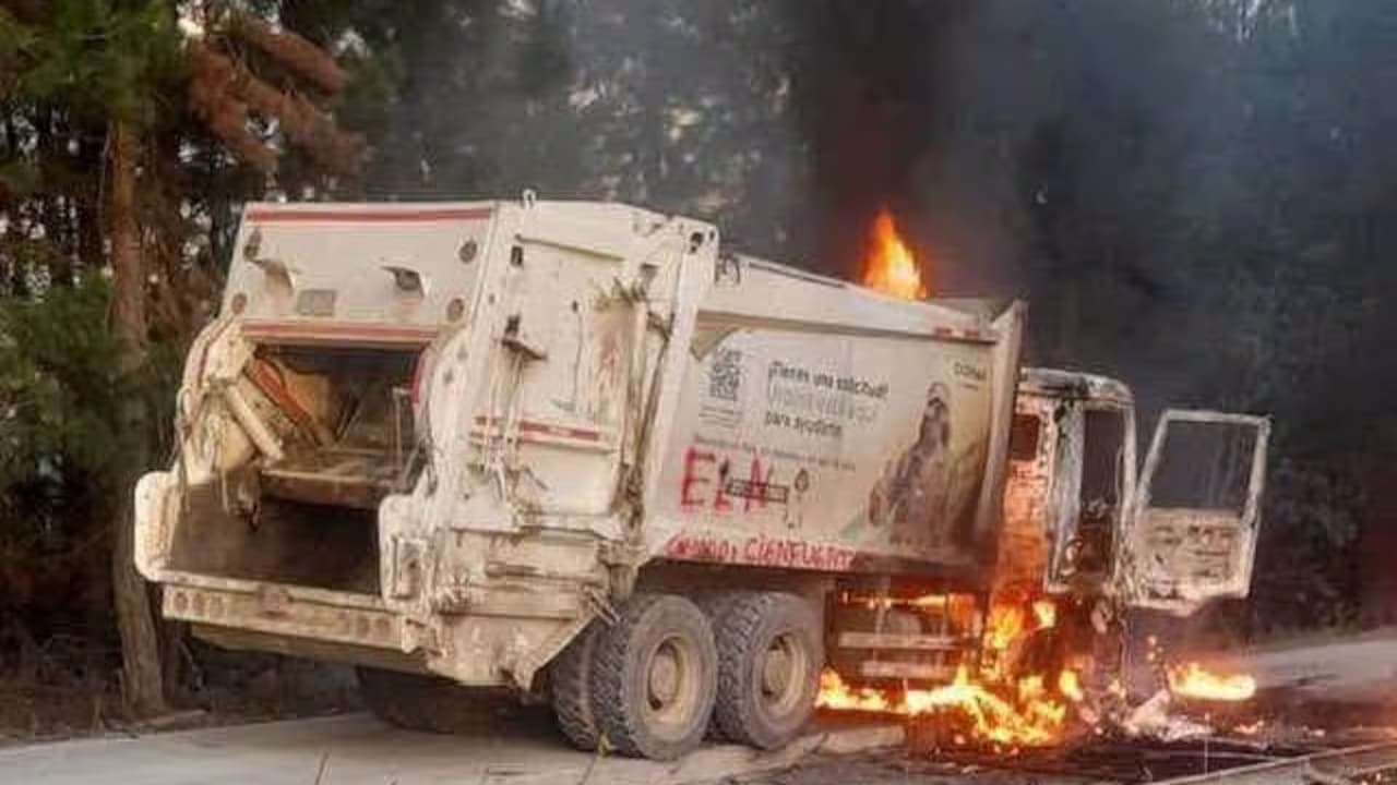 Camión recolector de basura en llamas, con la sigla ELN pintada en un costado, sobre una vía rural de Popayán