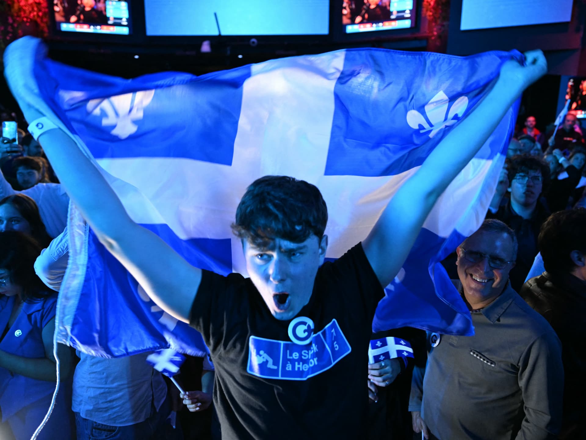 Un simpatizante del Partido Quebequés celebra con la bandera de Quebec la noche electoral