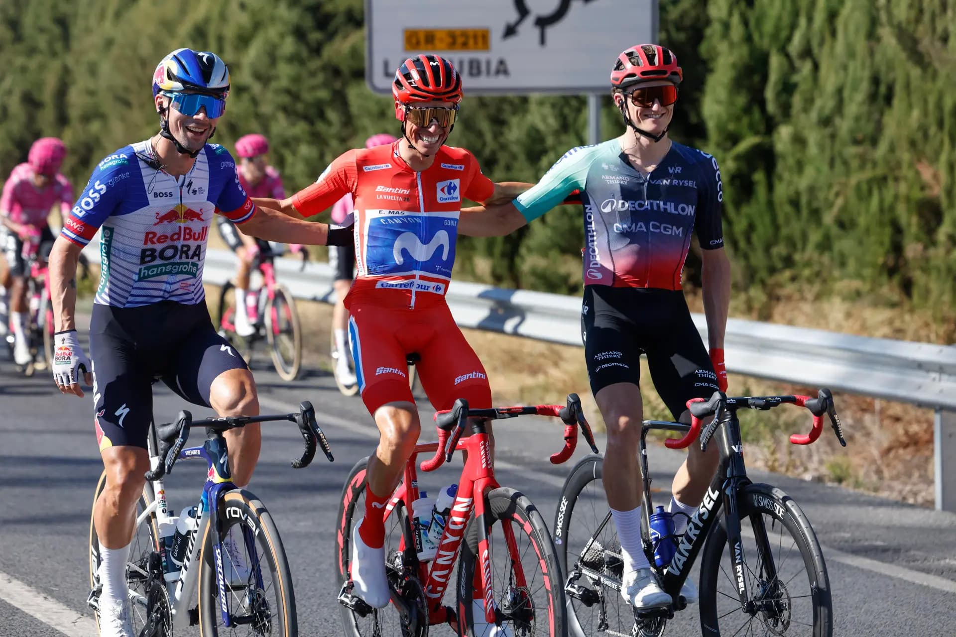 Enric Mas, con el maillot rojo de líder, rueda abrazado a Primoz Roglic y Felix Gall en la última etapa de la Vuelta