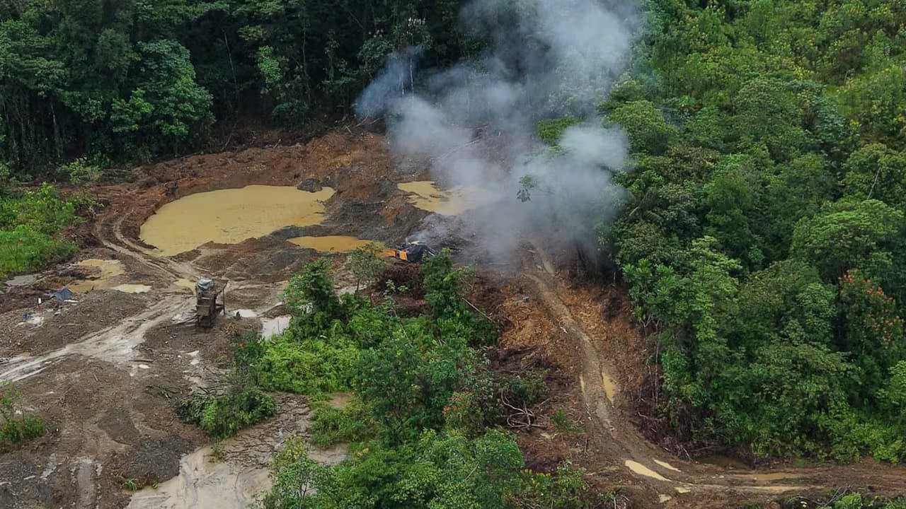 Vista aérea de una mina ilegal en la selva del Chocó con maquinaria destruida y humo