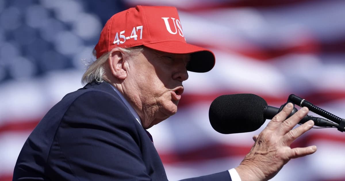 Donald Trump habla con una gorra roja frente a una bandera de Estados Unidos en un mitin en Bullhead City, Arizona