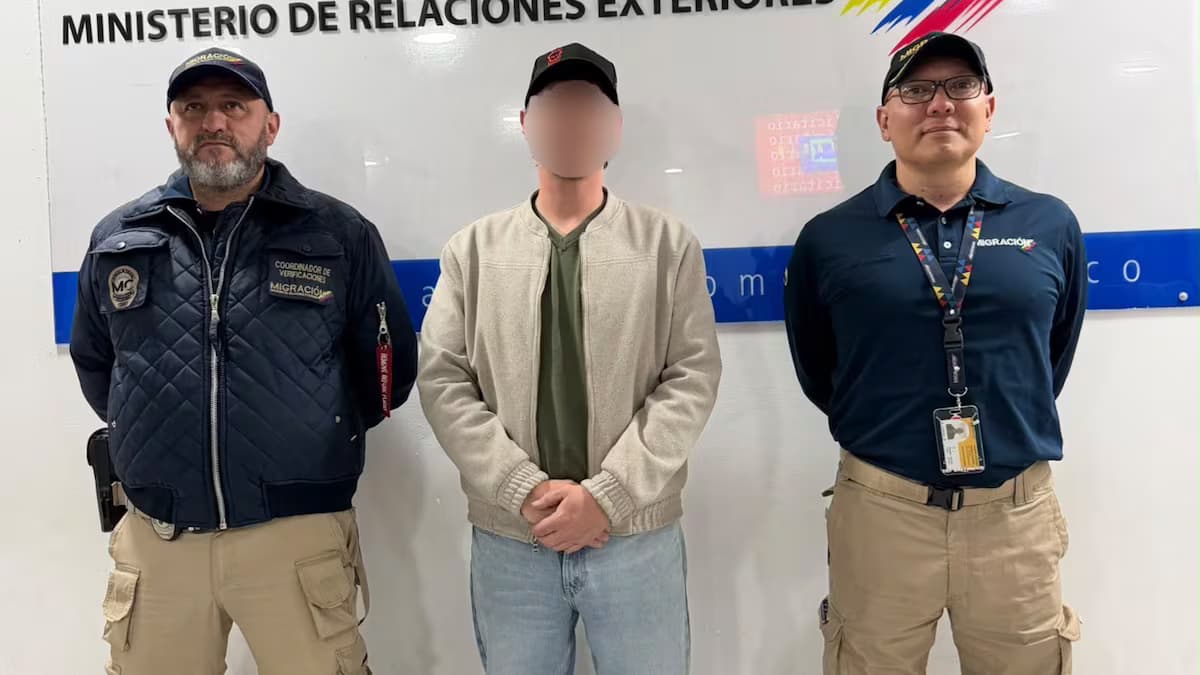 Sergei Vagin, con el rostro difuminado, entre dos funcionarios de Migración Colombia