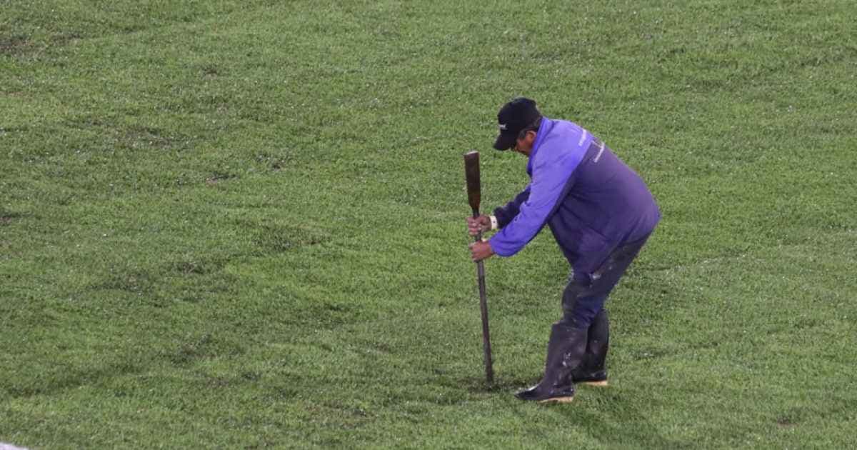Un operario revisa con una herramienta el estado de la grama del estadio El Campín