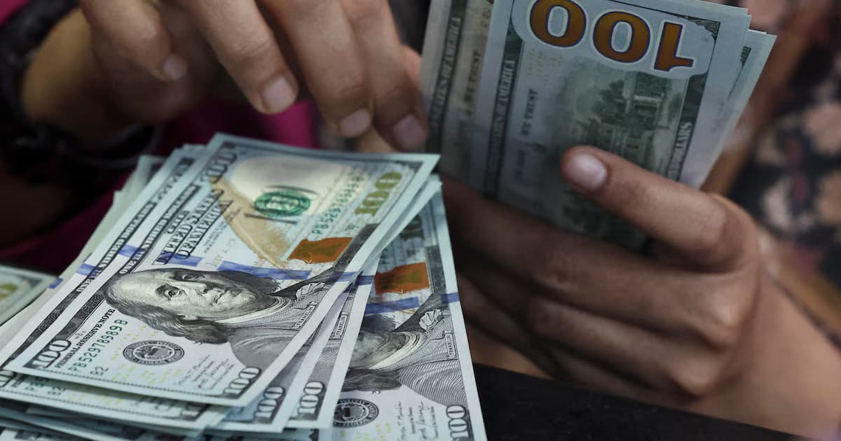 Una persona cuenta billetes de 100 dólares