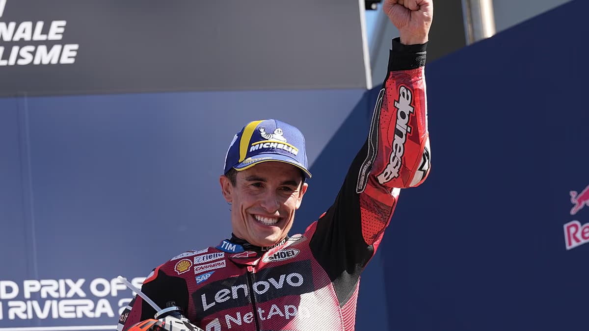 Marc Márquez, con gorra y mono rojo de Ducati, levanta el puño en el podio de Misano