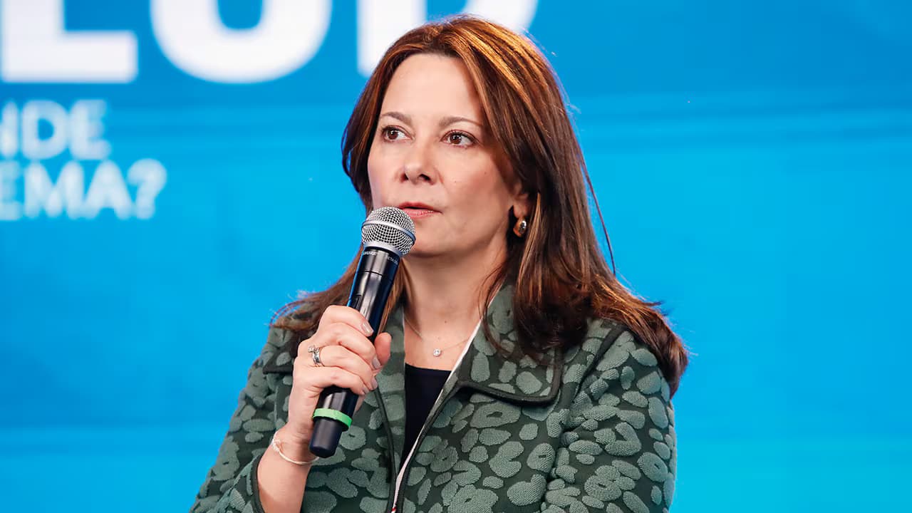 Ana María Vesga habla con un micrófono en la mano durante un foro
