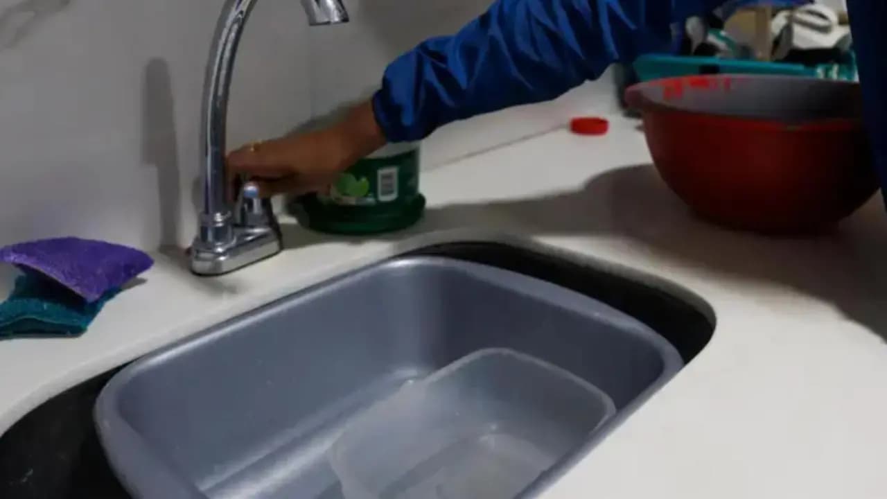 Una persona abre la llave de la cocina durante el racionamiento de agua en Medellín