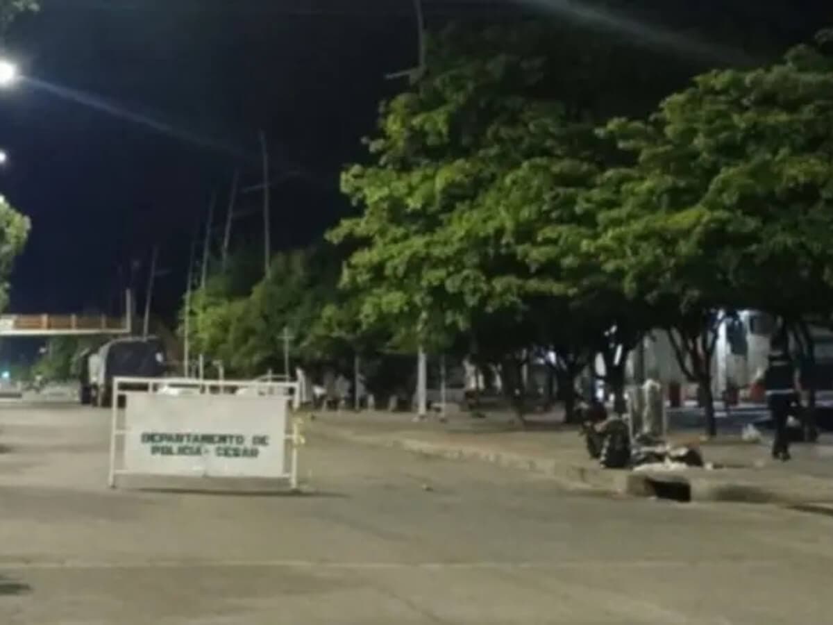 Vía cerrada con una valla del Departamento de Policía Cesar frente a la estación de Aguachica, de noche