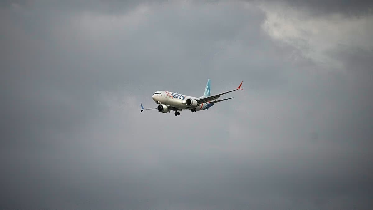 Un avión de FlyDubai en vuelo bajo un cielo nublado