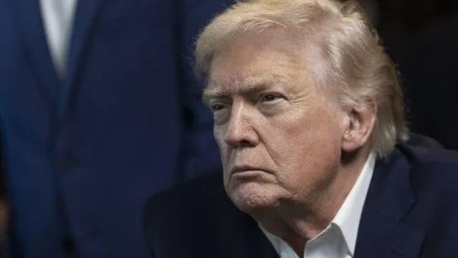 El presidente Donald Trump, sentado y con gesto serio, durante un acto oficial