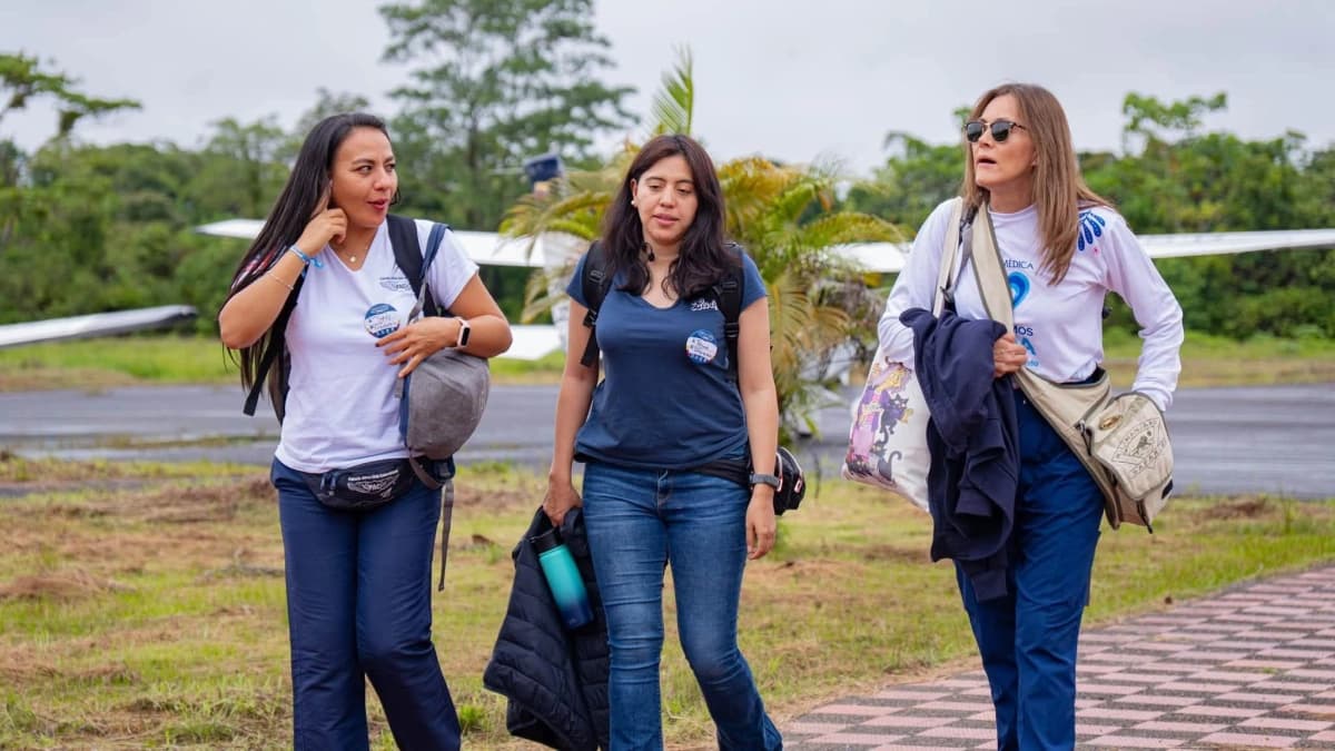 Integrantes de la misión médica caminan por la pista de un aeródromo del Chocó junto a una avioneta
