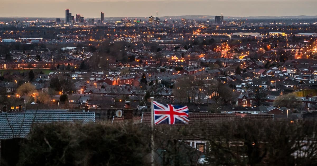 Bandera británica sobre los tejados de Mánchester al anochecer