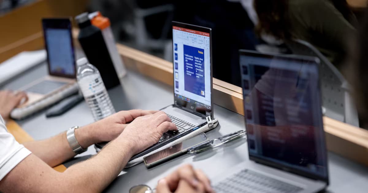 Personas trabajan en computadores portátiles sobre una mesa