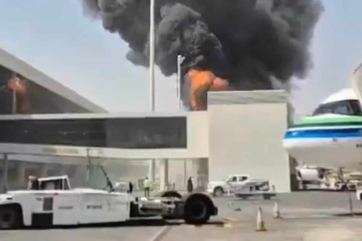 Una columna de humo negro y fuego se eleva sobre una terminal del aeropuerto de Riad, junto a un avión estacionado