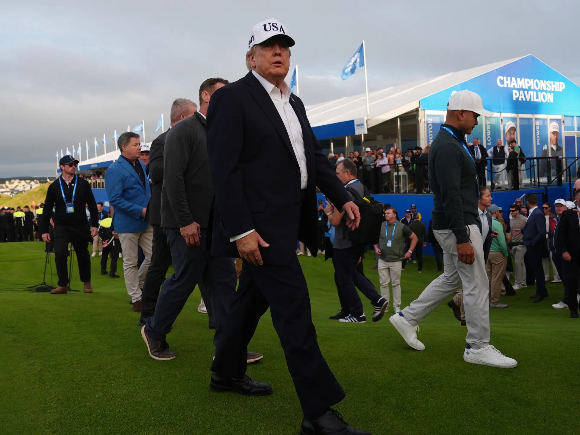 Donald Trump, con gorra blanca, camina por el campo de golf de Doonbeg entre asistentes al Abierto de Irlanda